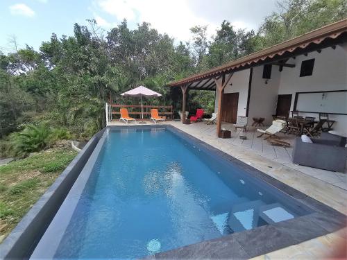a swimming pool in front of a house at Villa Mahogany in Deshaies