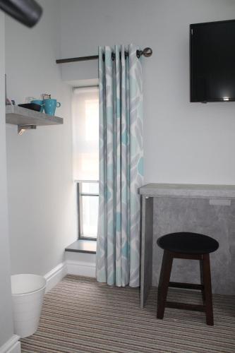 a bathroom with a toilet and a shower curtain at The Royal Hotel and Bar in Lancaster