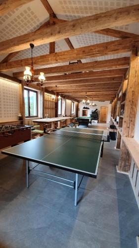 a ping pong table in a large room with wooden ceilings at Magic House Under Arber in Bayerisch Eisenstein