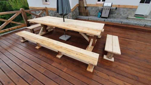 a wooden picnic table and benches on a deck at Magic House Under Arber in Bayerisch Eisenstein