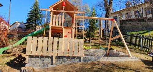 a playground with a slide and a swing set at Magic House Under Arber in Bayerisch Eisenstein