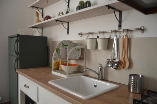 a kitchen counter with a sink and a refrigerator at Etesia Vacation Home in Acitrezza