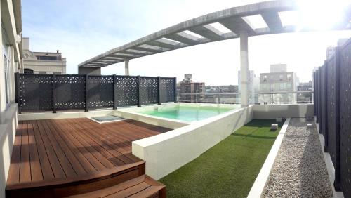 a rooftop deck with a swimming pool on a building at Land Plaza La Plata in La Plata