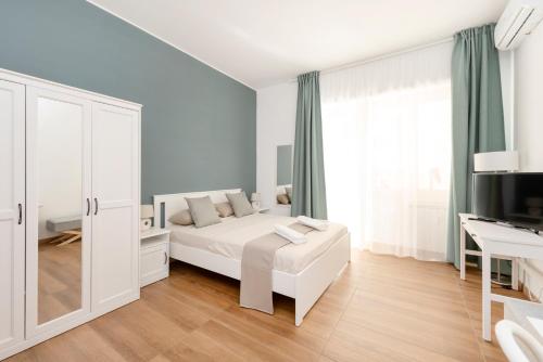 a white bedroom with a bed and a desk at B&B Il Dogandiere in Rome