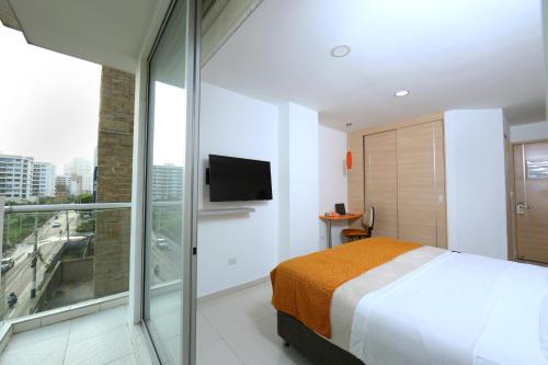 una camera con letto e porta scorrevole in vetro di Hotel Cabreromar By GEH Suites a Cartagena de Indias