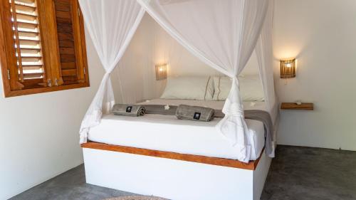 a bedroom with a bed with a canopy at Villa Dunas by Preabeach Experience in Prea