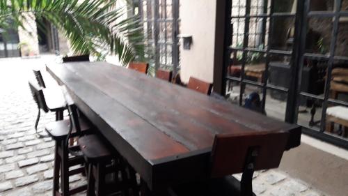 a large wooden table with chairs in front of a building at LA CASITA in Buenos Aires