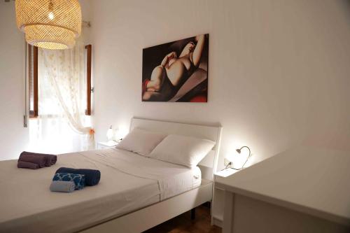 a white bedroom with a bed and a picture on the wall at casa Ada in SantʼAntìoco