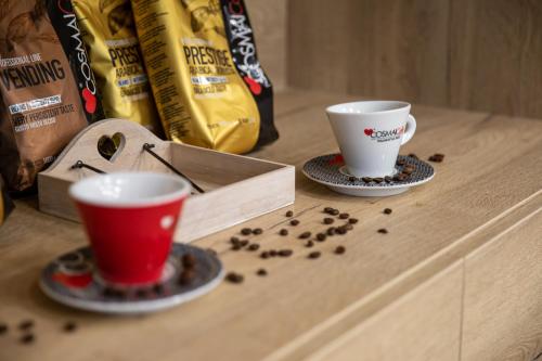 two cups sitting on a table with coffee beans at Lignum Hotel in Miskolctapolca