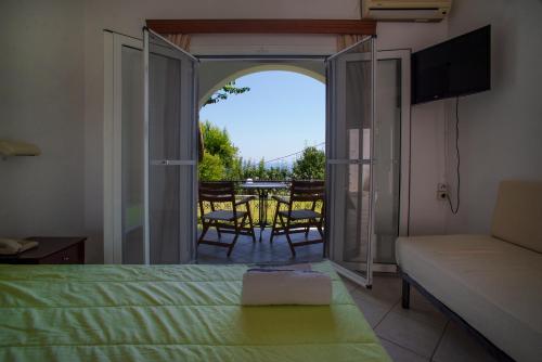 a bedroom with a bed and a view of a patio at Spiros Studios in Parga