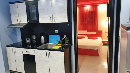 a kitchen with a sink and a room with a bed at Perfect Suites in Neos Marmaras