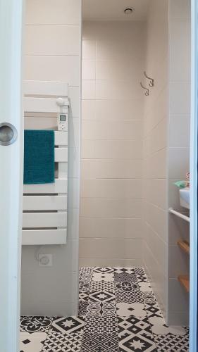 uma casa de banho com piso em azulejo preto e branco em CDG Aparts em Le Mesnil-Amelot
