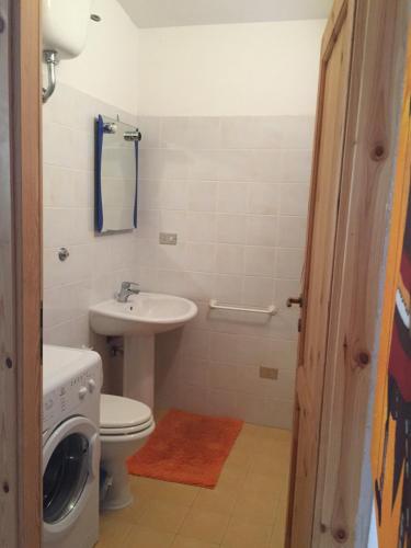a bathroom with a washing machine and a sink at Casa Mare in Solanas
