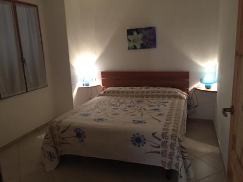 a bedroom with a bed and two lights on two tables at Casa Mare in Solanas