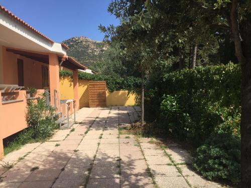 a walkway in front of a house with trees at Casa Mare in Solanas