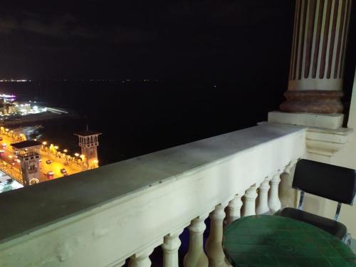 a chair sitting on a balcony at night at Stanley Bridge Apartment in Alexandria