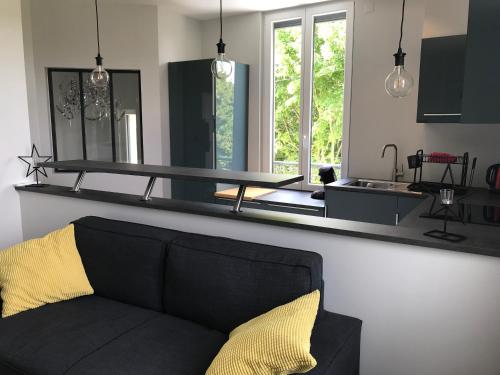 eine schwarze Couch in einer Küche mit Spiegel in der Unterkunft bord de seine in Bar-sur-Seine