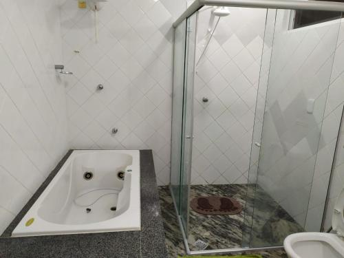 a bath tub in a bathroom with a shower at Condominio Arituba Tropical in Nísia Floresta