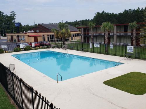 a large swimming pool with a fence around it at Florence Express Inn in Florence