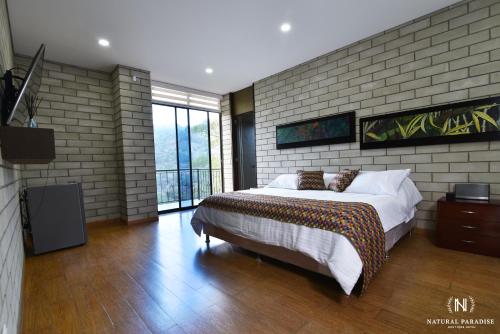 a bedroom with a bed and a brick wall at Home Boutique Natural Paradise in La Vega