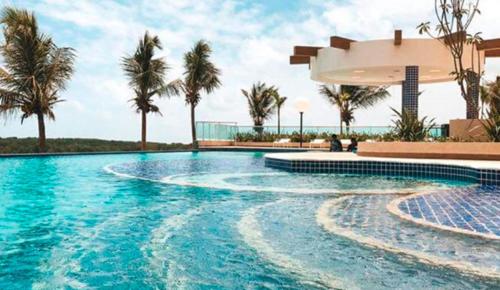 ein Swimmingpool mit Palmen und einem Gebäude in der Unterkunft Salinas Park Resort in Salinópolis