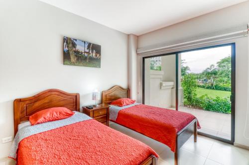 a bedroom with two beds and a large window at Jaco Bay 2102 in Jacó