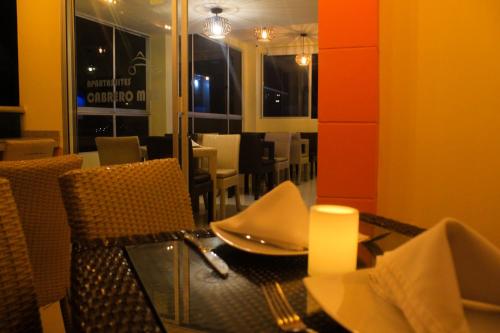 a dining room with a table and chairs and a window at Hotel Cabreromar in Cartagena de Indias