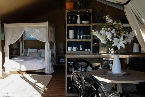 a bedroom with a bed and a table with a vase of flowers at Rosewood Farmstay in Binda