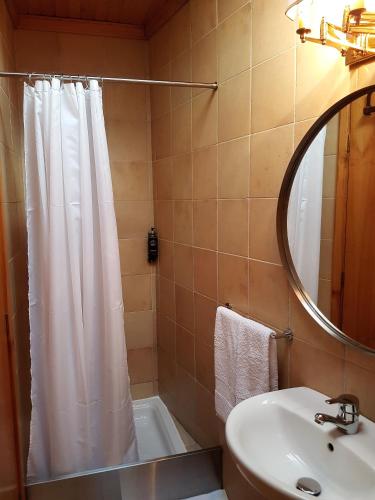 a bathroom with a shower curtain and a sink at Abrigo Montesinho in Montezinho