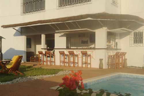 a house with a swimming pool and chairs and a building at Residence Helios in Abidjan