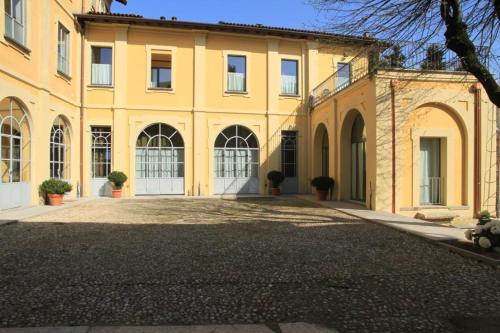a large yellow building with a driveway in front of it at Lisander B&B suite and terrace in Seregno