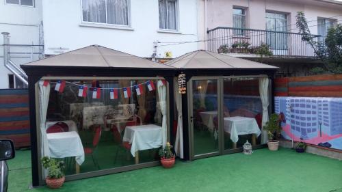 a black gazebo with a table and chairs at Hostal Los Castaños in Viña del Mar