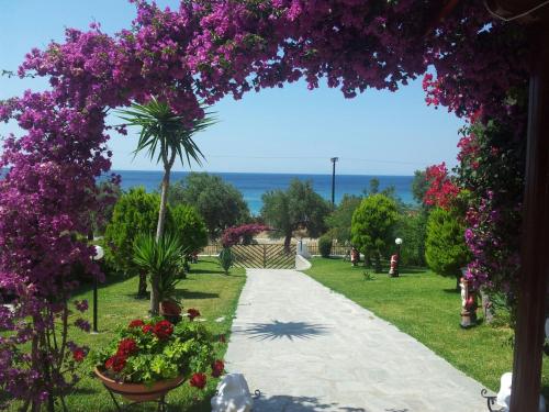 a walkway in a park with purple flowers at Ianos in Nea Skioni