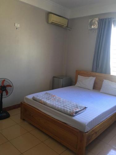 sypialnia z łóżkiem z białym materacem i wentylatorem w obiekcie Khách sạn Hong Kong w mieście Hòn Một