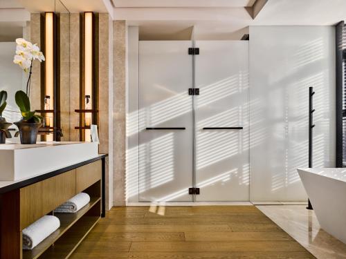 a bathroom with a sliding glass shower door at The PuXuan Hotel and Spa in Beijing