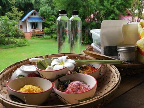 a tray with bowls of food on a table at Huensala Homestay in Ban Wang Khon