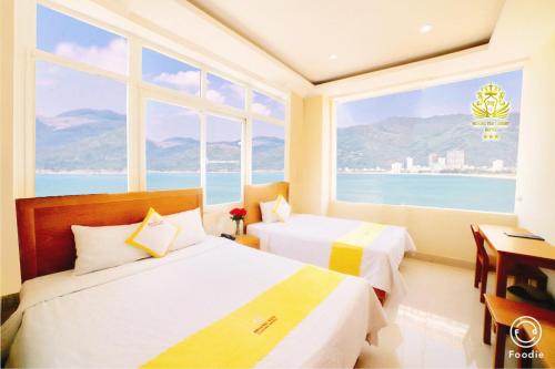 two beds in a room with a view of the ocean at Hoang Yen Canary Hotel in Quy Nhon