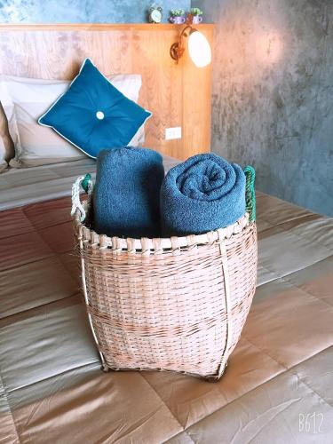 a basket filled with towels on a bed at Lanta Sabai Day House in Ko Lanta