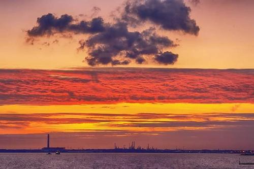 a sunset over a body of water with the sky at The Waters Edge in Lee-on-the-Solent