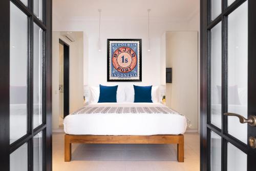Schlafzimmer mit einem Kingsize-Bett und blauen Kissen in der Unterkunft Villa Opihr in Seminyak