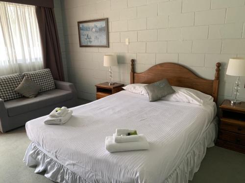 1 dormitorio con 1 cama con 2 toallas en Robertson Country Motel en Robertson