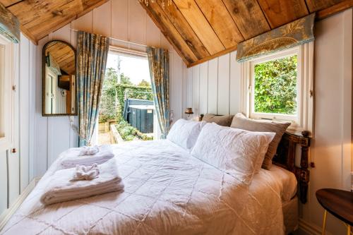 um quarto com uma cama grande e uma janela em The Settlers Hut em Oneroa