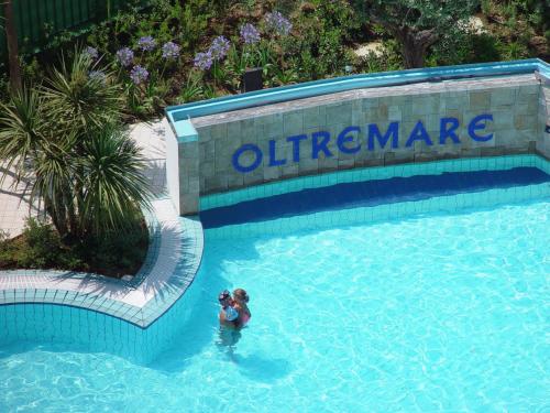 two people swimming in a swimming pool in a swimming pool at Residence Oltremare in San Benedetto del Tronto