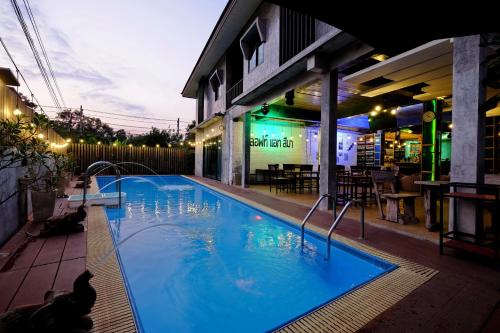a large blue swimming pool in front of a building at ลอฟท์แอทสีมา สาขา2 in Nakhon Ratchasima