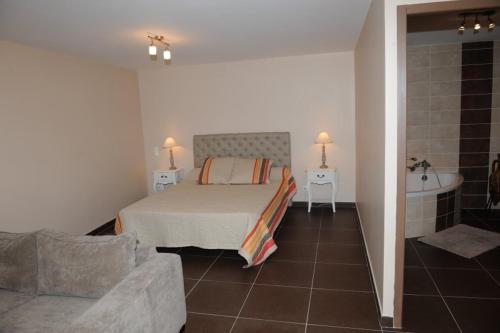 a bedroom with a bed and a bathroom with a tub at Gîte aux Berges du Canal in Capestang