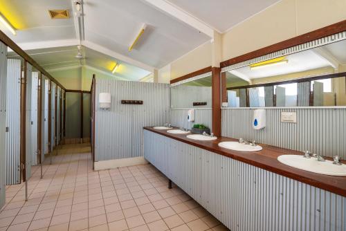 a bathroom with a row of sinks and mirrors at Discovery Parks - Cloncurry in Cloncurry
