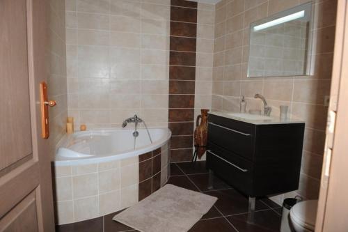 a bathroom with a tub and a sink and a toilet at Gîte aux Berges du Canal in Capestang