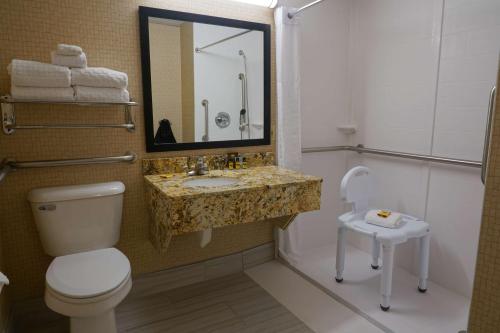 a bathroom with a toilet and a sink and a mirror at Best Western Plus Morristown Conference Center in Morristown
