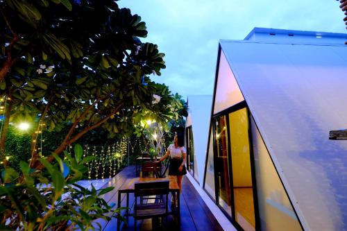 a woman standing on the balcony of a house at ลอฟท์แอทสีมา สาขา2 in Nakhon Ratchasima