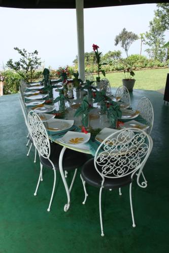 uma mesa longa com cadeiras e pratos em Kelburne Estate em Haputale